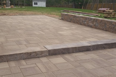 Inspiration for a mid-sized rustic backyard brick patio remodel in Manchester with no cover