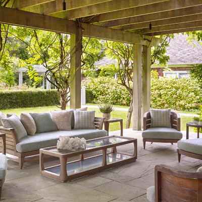 Patio - large traditional backyard stone patio idea in New York with a pergola