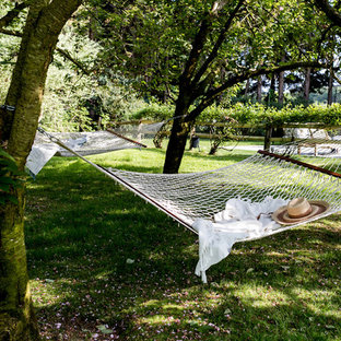Foto di un ampio patio o portico stile marino dietro casa con un giardino in vaso, pavimentazioni in pietra naturale e un tetto a sbalzo