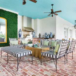 Idee per un grande patio o portico classico dietro casa con pavimentazioni in mattoni e un tetto a sbalzo