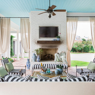 Foto di un grande patio o portico chic dietro casa con pavimentazioni in mattoni e un tetto a sbalzo
