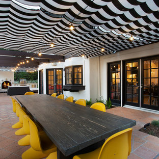 Example of a mid-sized eclectic side yard tile patio kitchen design in Los Angeles with an awning