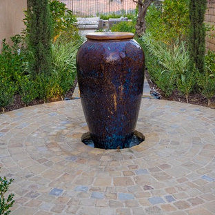 Idee per un grande patio o portico bohémian nel cortile laterale con un focolare e pavimentazioni in pietra naturale
