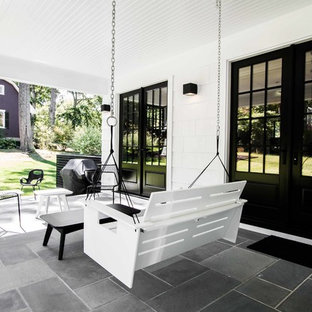 Idee per un patio o portico eclettico di medie dimensioni e dietro casa con cemento stampato e un tetto a sbalzo