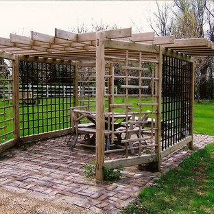Example of a small eclectic backyard brick patio design in Minneapolis with a pergola
