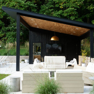 Idee per un patio o portico contemporaneo con lastre di cemento e un tetto a sbalzo