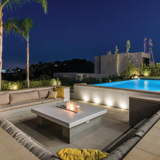 Ispirazione per un grande patio o portico moderno dietro casa con un focolare e nessuna copertura