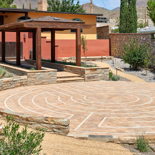 Immagine di un patio o portico tradizionale dietro casa con pavimentazioni in cemento e un gazebo o capanno