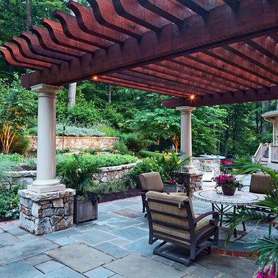 Example of a mid-sized classic backyard concrete paver patio design in DC Metro with a pergola