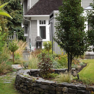 Immagine di un ampio patio o portico stile marinaro dietro casa con pavimentazioni in pietra naturale e nessuna copertura