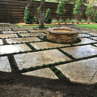 Immagine di un ampio patio o portico eclettico dietro casa con un focolare