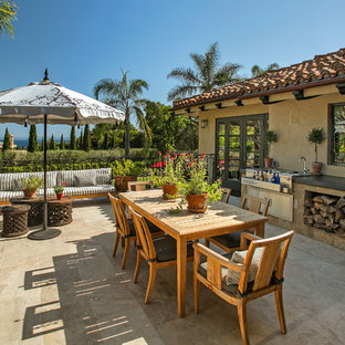Large tuscan stone patio kitchen photo in Santa Barbara with no cover