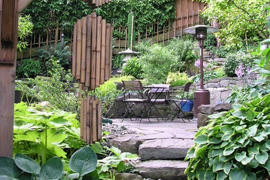 Large arts and crafts backyard stone patio photo in Portland with no cover