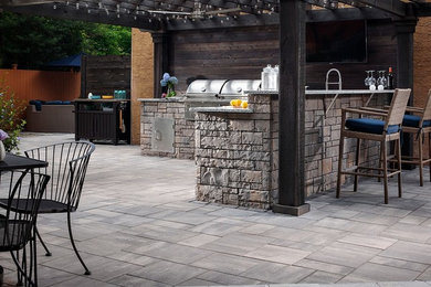 Inspiration for a mid-sized timeless backyard stone patio kitchen remodel in Philadelphia with a pergola
