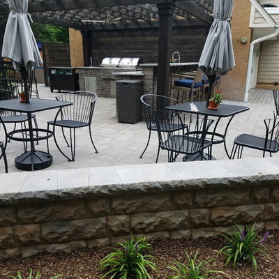 Mid-sized elegant backyard stone patio kitchen photo in Philadelphia with a pergola