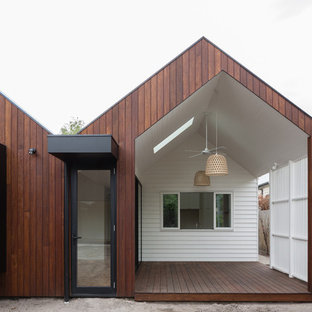 Aménagement d'une terrasse arrière scandinave de taille moyenne avec une terrasse en bois et une extension de toiture.