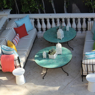 Esempio di un patio o portico mediterraneo con piastrelle e nessuna copertura