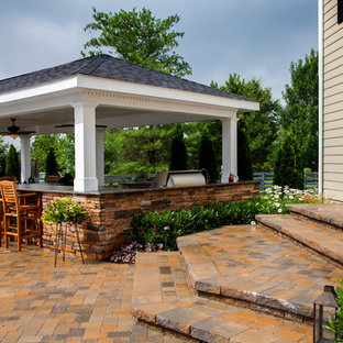 Large elegant backyard stone patio kitchen photo in Orange County with a gazebo