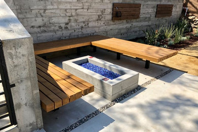 Patio - large modern backyard concrete paver patio idea in Los Angeles with a fire pit and no cover