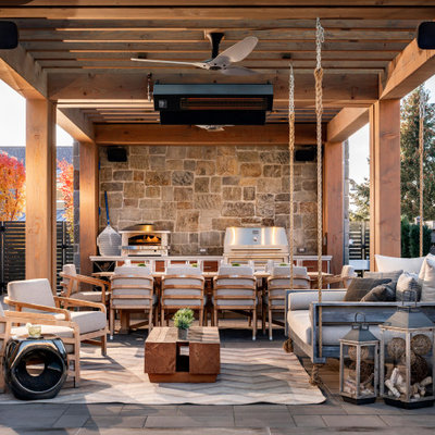 Huge cottage backyard concrete paver patio kitchen photo in Salt Lake City with a pergola