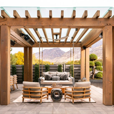 Example of a huge farmhouse backyard concrete paver patio kitchen design in Salt Lake City with a pergola