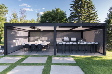 Modelo de patio minimalista de tamaño medio en patio lateral con cocina exterior, adoquines de hormigón y pérgola