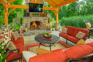 Example of a large transitional backyard stone patio kitchen design in Philadelphia with a roof extension