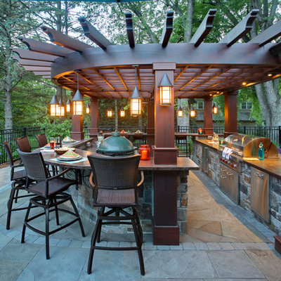 Inspiration for a transitional backyard stone patio kitchen remodel in Minneapolis with a pergola