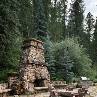 This is an example of a country backyard patio in Denver with no cover and with fireplace.