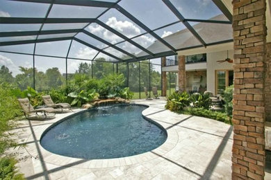 Ejemplo de piscina contemporánea de tamaño medio en patio trasero con adoquines de hormigón