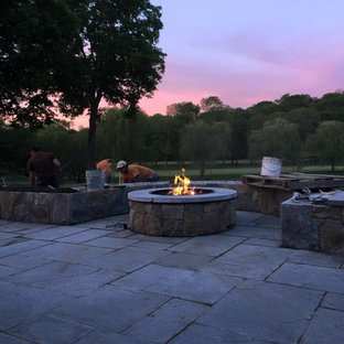 Ispirazione per un grande patio o portico tradizionale dietro casa con un focolare, pavimentazioni in pietra naturale e nessuna copertura