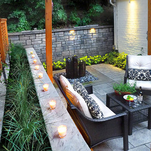 Foto di un patio o portico etnico di medie dimensioni e dietro casa con fontane, pavimentazioni in cemento e una pergola
