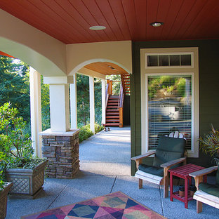 Foto di un grande patio o portico american style dietro casa con un tetto a sbalzo, un giardino in vaso e lastre di cemento
