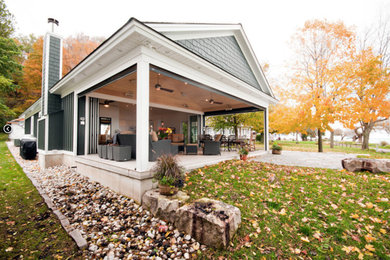 Inspiration pour une terrasse arrière traditionnelle de taille moyenne avec une dalle de béton et une extension de toiture.