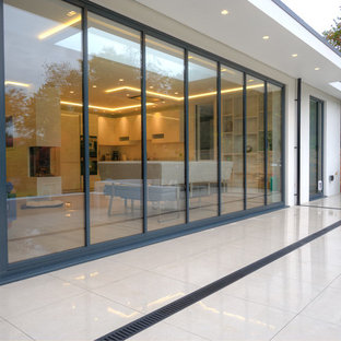 Foto di un grande patio o portico minimal dietro casa con piastrelle