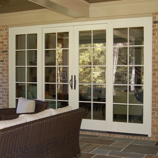 Immagine di un patio o portico chic di medie dimensioni e dietro casa con un focolare, graniglia di granito e un tetto a sbalzo