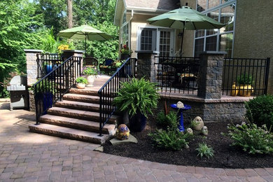 Diseño de patio clásico de tamaño medio sin cubierta en patio trasero con adoquines de piedra natural