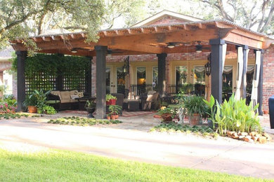 Large front yard patio photo in Dallas with a pergola