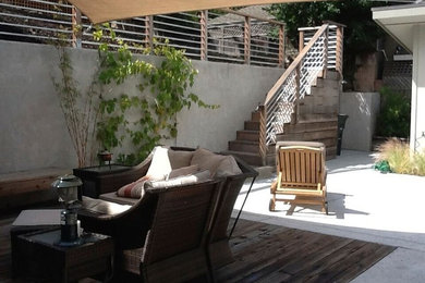 Foto de patio de estilo americano de tamaño medio en patio trasero con cocina exterior, entablado y toldo