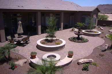 Inspiration for a medium sized back patio in Phoenix with a fire feature, brick paving and a roof extension.