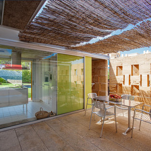 Ejemplo de patio actual con suelo de baldosas y pérgola