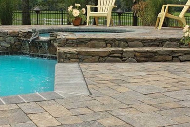 Example of a large classic backyard concrete paver patio fountain design in Other