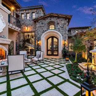 Immagine di un ampio patio o portico stile shabby in cortile con un focolare, pavimentazioni in cemento e nessuna copertura