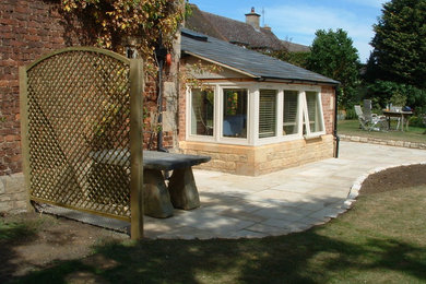 Exemple d'une terrasse chic avec des pavés en pierre naturelle.