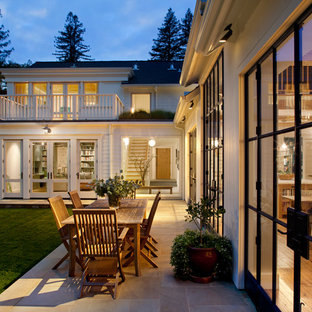 Foto di un patio o portico country dietro casa con piastrelle e nessuna copertura