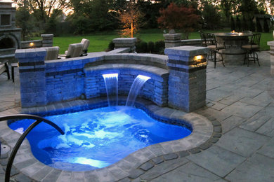 Pool - large rustic backyard stone pool idea in Detroit