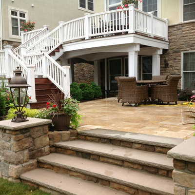 Example of a mid-sized trendy backyard stone patio kitchen design in New York