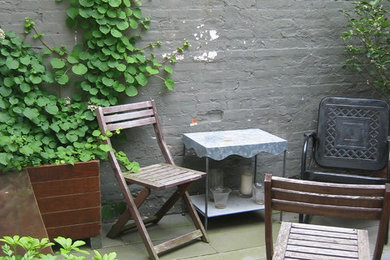 Ejemplo de patio contemporáneo pequeño sin cubierta en patio trasero con jardín de macetas y adoquines de piedra natural