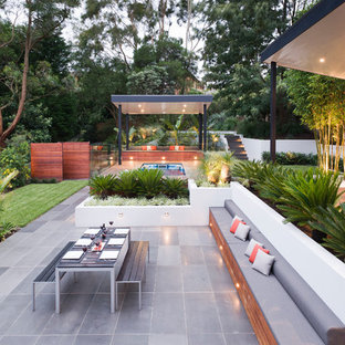 Idee per un grande patio o portico minimal dietro casa con pedane e un gazebo o capanno