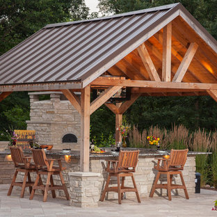 Esempio di un grande patio o portico tradizionale dietro casa con pavimentazioni in pietra naturale e un gazebo o capanno